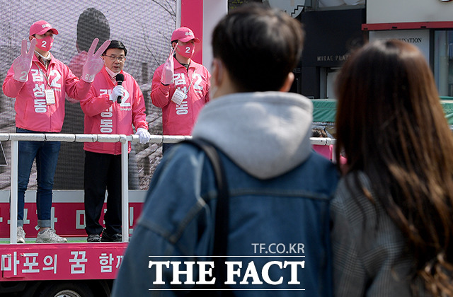 김 후보 유세 현장을 바라보는 젊은 커플