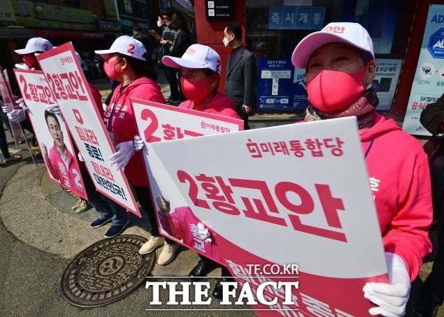 시선 집중! 황교안 후보의 선거운동원들이 빨간색 마스크와 이름 적힌 모자를 쓰고 유세를 하고 있다.