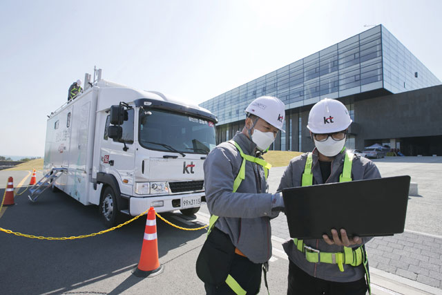 KT 직원들이 경북 경주의 신종 코로나바이러스 감염증 생활치료센터에서 차량 이동기지국을 배치한 뒤 품질을 점검하고 있다. /KT 제공