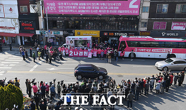 차도를 사이에 두고 선 유세차와 주민들