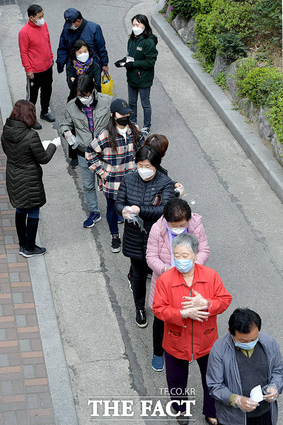 투표소를 찾은 유권자들에게 일회용 비닐 장갑을 나눠주는 투표 사무원