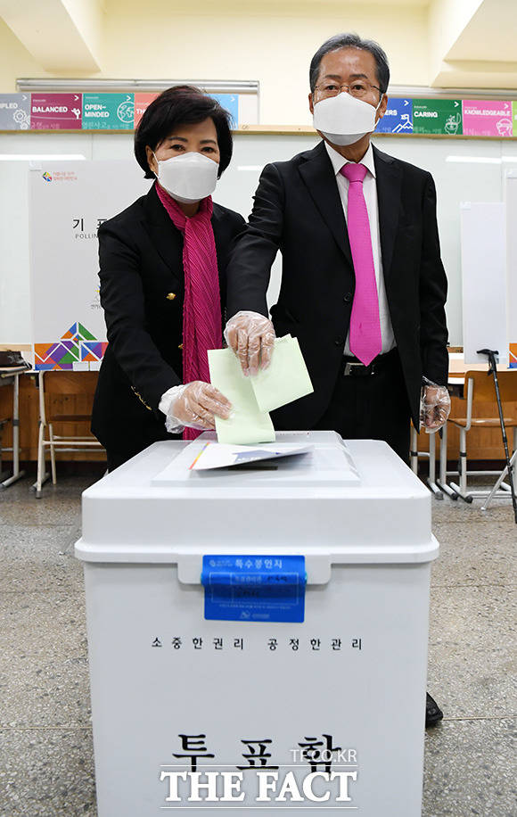 21대 총선 대구 수성구을에 출마한 홍준표 무소속 후보가 투표일인 15일 오전 대구 수성 중앙고등학교 투표소에서 아내 이순삼 씨와 투표를 마친뒤 기표함에 투표 용지를 넣고 있다./대구=임영무 기자