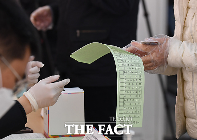 비닐장갑을 착용하고 받는 투표용지