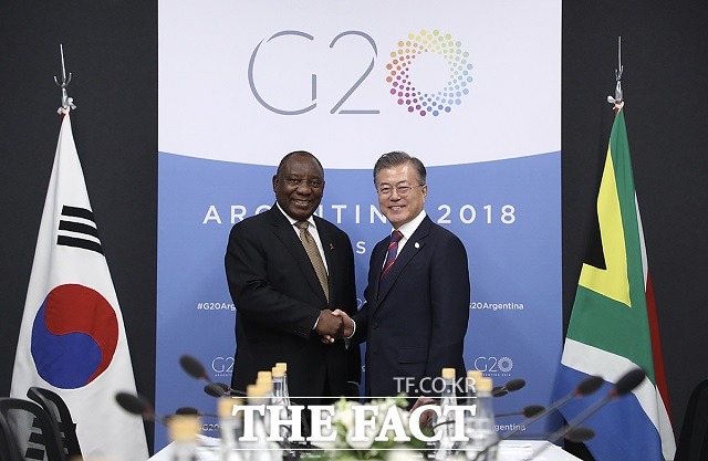 문재인 대통령이 24일 마타멜라 시릴 라마포사 남아공 대통령과 통화에서 코로나19 관련 지원 방안을 검토하겠다고 말했다. 사진은 2018년 12월 아르헨티나 부에노스아이레스 코스타 살게로 센터 G20 양자회담장에서 정상회담에 앞서 악수하는 양국 정상. /청와대 제공