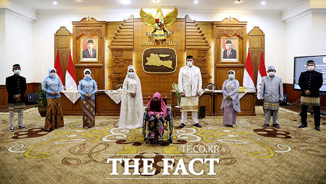 사회적 거리두기 25일(현지시간) 인도네시아 동자바 수라바야의 정부청사에서 결혼식을 올린 후 기념사진을 찍는 신랑·신부와 그 가족들. /수라바야=AP.뉴시스