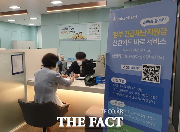 18일 오전 서울 종로구에 위치한 신한은행 영업지점에서 한 고객이 긴급재난지원금을 신청하고 있다. /종로=정소양 기자