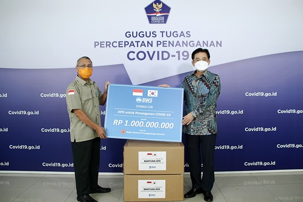 우리소다라은행은 인도네시아 자카르타의 국가재난방지청에 방호복 5000벌을 기부했다. 최정훈 우리소다라은행 법인장(사진 오른쪽)과 인도네시아 국가재난방지청 이브누(Ibnu)국장이 기념촬영을 하고 있다. /우리은행 제공