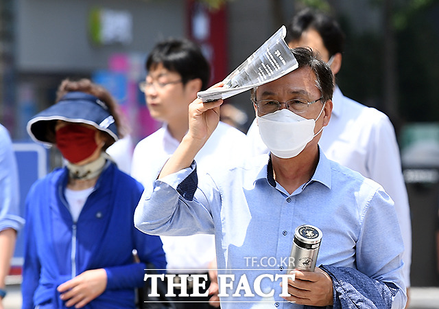 서울의 한낮 기온이 26도로 무더운 날씨를 보이는 4일 오후 서울 광화문 일대에서 시민들이 더위를 피해 걸음을 재촉하고 있다.