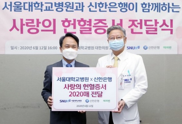 신한은행 진옥동 행장(왼쪽)이 지난 12일 서울 종로구 대학로 서울대학교병원 대한의원 본관에서 진행된 서울대학교병원과 신한은행이 함께하는 사랑의 헌혈증서 전달식에서 김연수 서울대학교병원 원장과 기념 촬영을 하고 있다. / 신한은행 제공