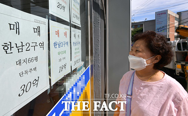 최근 부동산 시장이 과열 양상을 보이고 있는 가운데 15일 오후 한 시민이 서울 용산구의 한 부동산중개업소에 붙은 매매 가격 안내문을 보고 있다. /이덕인 기자