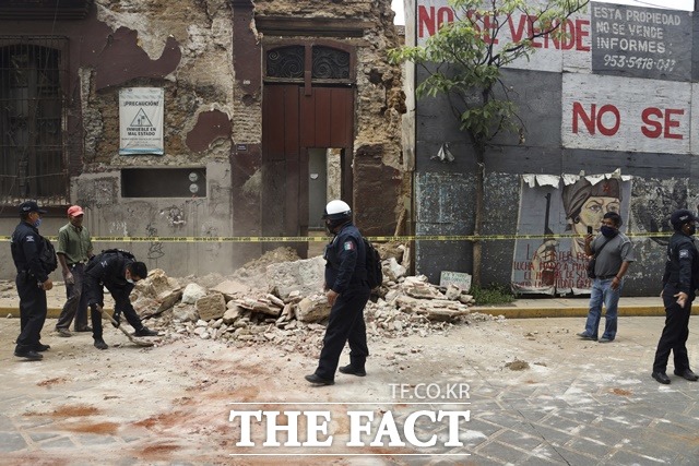 멕시코 남부에서 규모 7.4의 강진이 발생해 23일(현지시간) 오악사카에서 경찰이 지진으로 파손된 건물 잔해를 치우고 있다. 관계 당국은 이 지진으로 최소 2명이 숨졌으며 주민들은 건물 밖으로 대피했다. /(멕시코)오악사카=AP/뉴시스