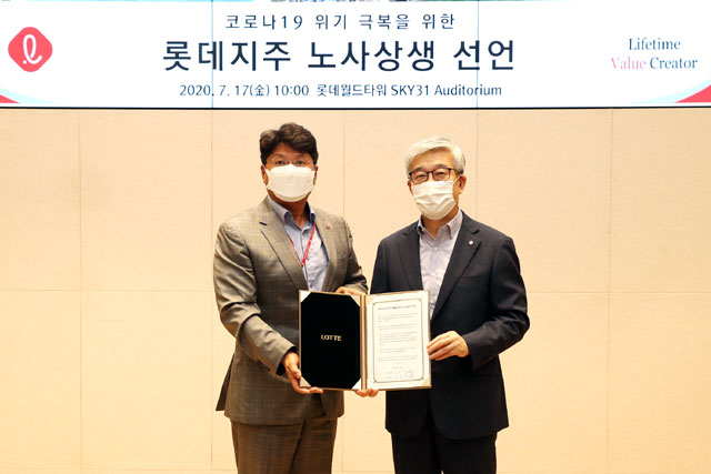 롯데지주 사용자 대표 송용덕 부회장(오른쪽)과 근로자 대표 김봉세 수석이 17일 서울 잠실 롯데월드타워에서 열린 롯데지주 노사 협력 선언식에 참석해 선언문에 서명한 뒤 기념 촬영하고 있다. /롯데지주 제공