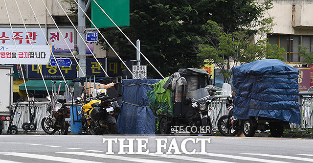 천막으로 꽁꽁 묶어 도로에 주차한 운반차량들.