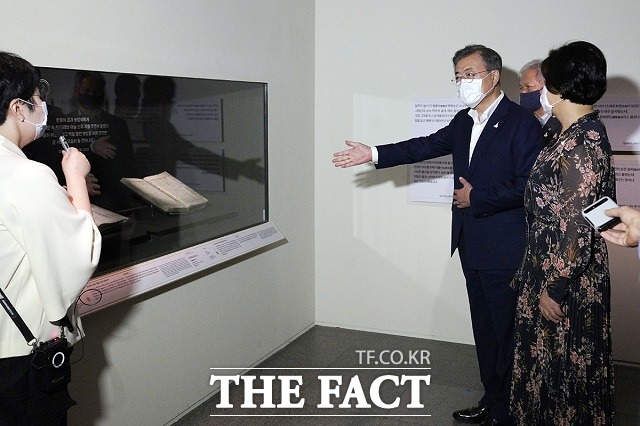 마스크를 쓴 문 대통령이 30일 서울 용산구 국립중앙박물관을 방문해 새 보물 납시었네, 신국보보물전 2017-2019 특별전에 전시된 삼국사기와 삼국유사 앞에서 일정 거리를 두고 학예사와 대화를 나누는 모습이 눈길을 끈다. /청와대 제공