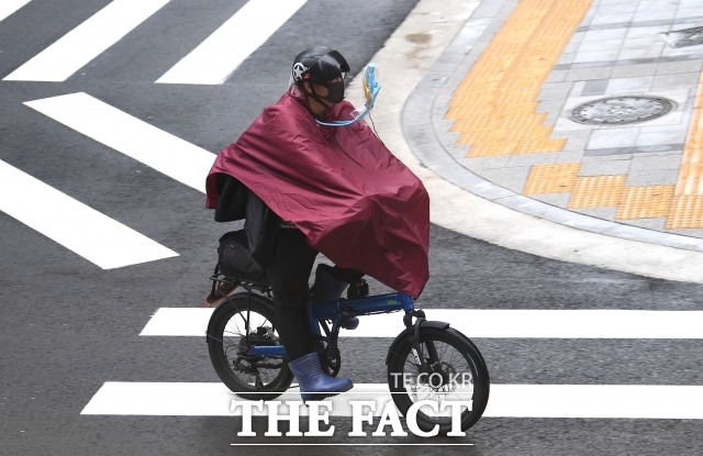 경기·서울에 강한 비가 내림에 따라 기상청이 경기 북부 등에 호우 특보를 내렸다. 사진은 지난달 비가 내리는 날씨가 계속되는 23일 오전 서울 시청 일대에서 한 시민이 비옷으로 무장한 채 자전거를 타고 이동하는 모습. /이새롬 기자