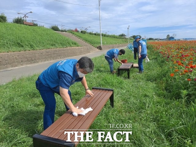 제선부와 환경자원그룹 직원들이 최근 이어진 장맛비로 더러워졌을 쉼터의자들을 직접 닦아 주민들이 둔치에서 편안하게 휴식할 수 있도록 했다./포항제철소 제공