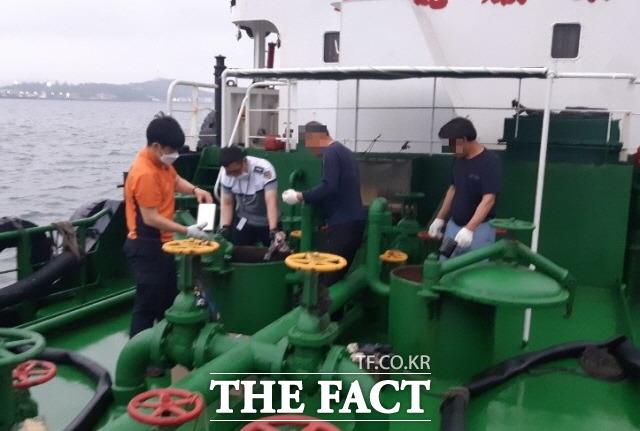 목포해경 대원이 연료공급용 화물유(C중유) 및 연료유(경유)시료를 채취하고 있다./목포해양경찰서 제공
