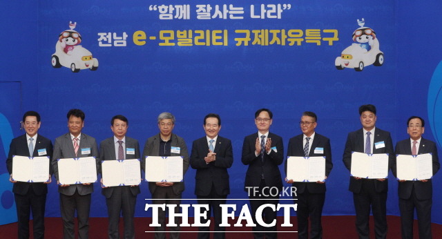 지난 6월 17일 오후 영광 대마산단 한국자동차연구원 전남본부에서 열린 전남 e-모빌리티 규제자유특구 투자협약식에 참석한 정세균 국무총리(가운데)와 김영록 전남도지사(왼쪽, 첫번째), 강성천 중소벤처기업부 차관(왼쪽, 여섯번째), 김준성 영광군수(오른쪽,첫번째),그리고 투자협약 관련업체 대표들/전남도청 제공