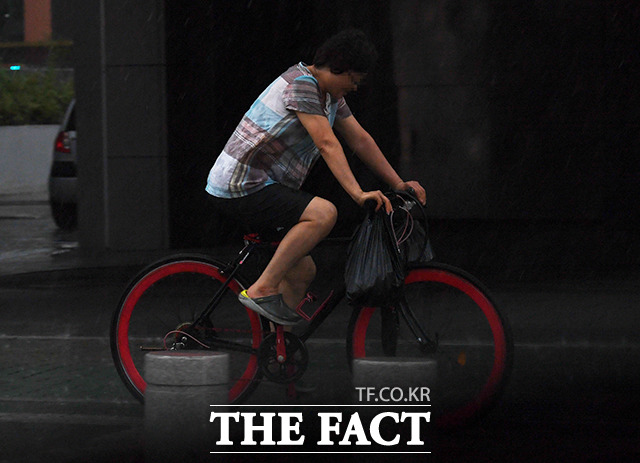 제5호 태풍 장미가 한반도에 상륙한 10일 오후 서울 강서구 염창역 인근에서 자전거를 탄 한 시민이 갑자긴 내리기 시작한 폭우를 맞으며 이동하고 있다./배정한 기자