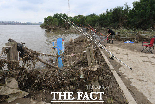 작업현장 인근에는 수해로 인해 아직 어지러운 모습인 가운데 시민들이 낚시를 즐기고 있다.