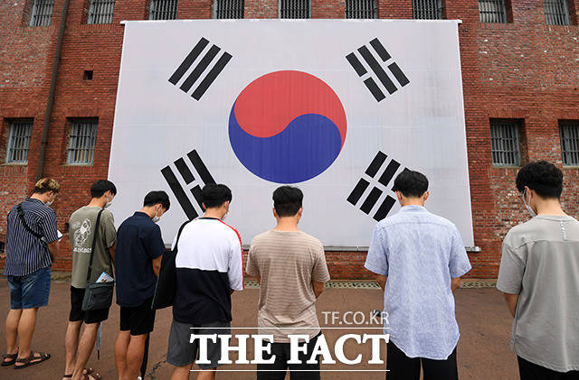 제75주년 광복절을 맞은 15일 오전 서울 서대문구 서대문형무소역사관을 찾은 학생들이 대형 태극기 앞에서 묵념을 하고 있다./임영무 기자