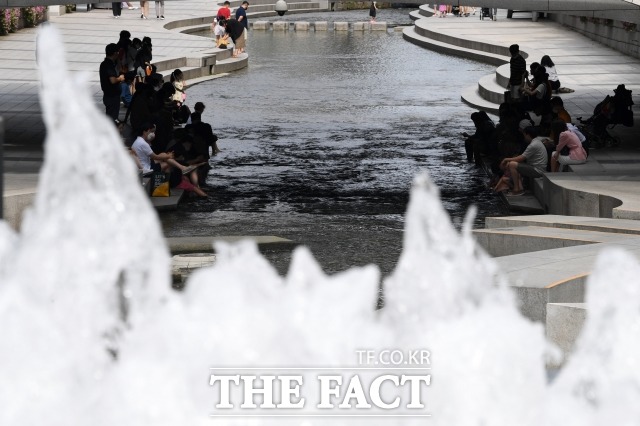 서울과 이천 최고 34도로 오늘보다 2도 가량이 높아지는 등 전국적으로 더위가 기승을 부리겠다. 사진은 중복인 지난달 26일 서울 중구 청계천을 찾아 발을 담그고 있는 시민들. /남윤호 기자