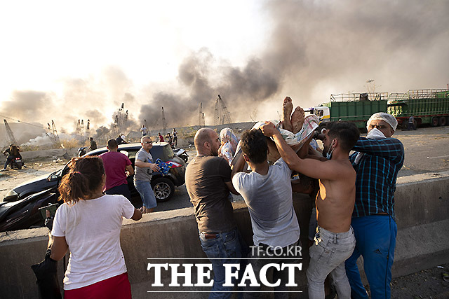 대폭발이 일어난 레바논 베이루트 항구에서 4일 시민들이 부상자를 들것에 실어 옮기고 있다. /베이루트=AP.뉴시스
