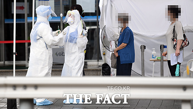 질병관리본부는 22일 오전 0시 기준 코로나19 확진자가 이틀 연속 300명대를 기록하고 있다고 발표했다. 사진은 지난 21일 서울 성북보건소에 마련된 코로나19 (신종 코로나바이러스 감염증) 선별진료소에서 의료진들이 방호복에 우비를 겹쳐 입고 비를 맞으며 분주히 움직이고 있는 모습. /이새롬 기자