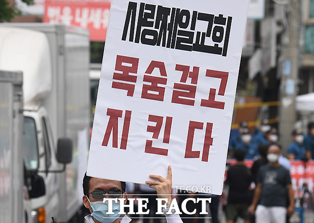 지난 21일 서울 성북구 사랑제일교회 앞에서 전광훈 목사의 변호인단이 기자회견을 하는 가운데, 신도들이 피켓 시위를 하는 모습. /이새롬 기자