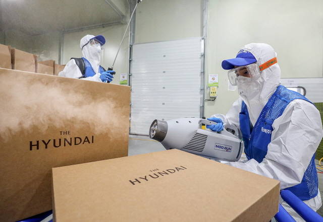 현대백화점이 추석 선물 배송 전 모든 과정에서 소독을 진행하기로 했다. 사진은 경기도 김포시에 위치한 물류센터에서 전문 방역업체 직원들이 초미립자 분사기를 활용해 선물세트를 소독하는 모습. /현대백화점 제공