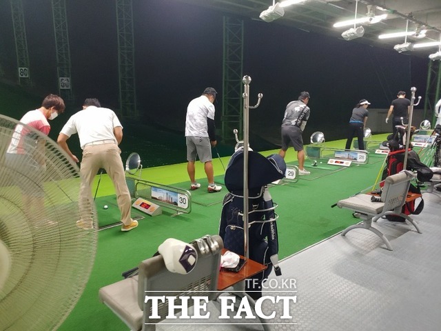 골프 레슨을 받고 있는 한 여성과 레슨 프로를 제외한 사람들이 마스크를 착용하지 않은 채 골프 연습을 하고 있다./ 광주=허지현 기자