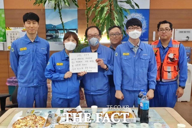 포항제철소 소결공장 직원들이 지난 3일 응원 메시지와 간식을 받아 기념사진을 찍고 있다./포항제철소 제공