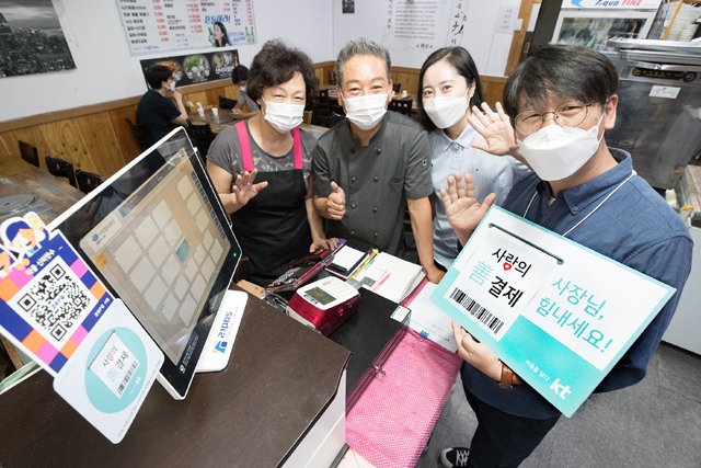KT 직원들이 서울 광화문 한 주상복합건물의 음식점을 찾아 선결제를 진행하고 있다. /KT 제공