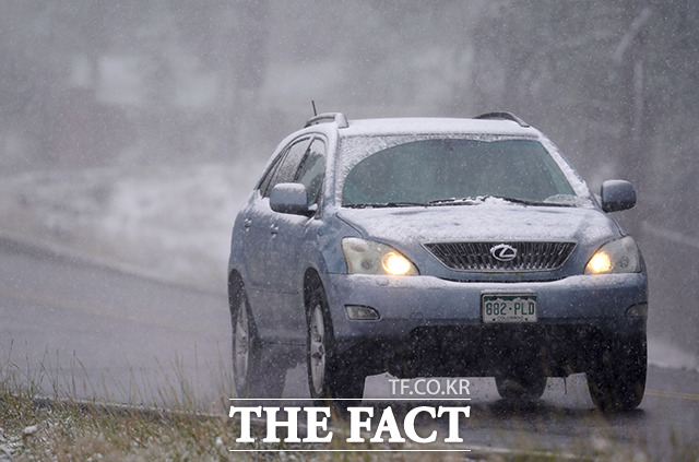 8일(현지시간) 미 콜로라도주 에버그린 산간 지역에 눈을 동반한 폭풍이 휩쓸고 지나가 한 운전자가 내리는 눈을 맞으며 조심스레 차량을 운전하고 있다.