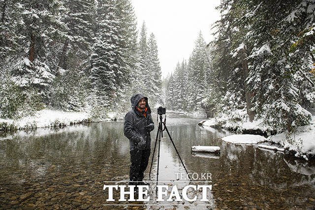 9일(현지시간) 미 콜로라도주 스키 휴양 도시 아스펜의 눈 내리는 링컨 크리크에서 한 남성이 사진을 찍고 있다.