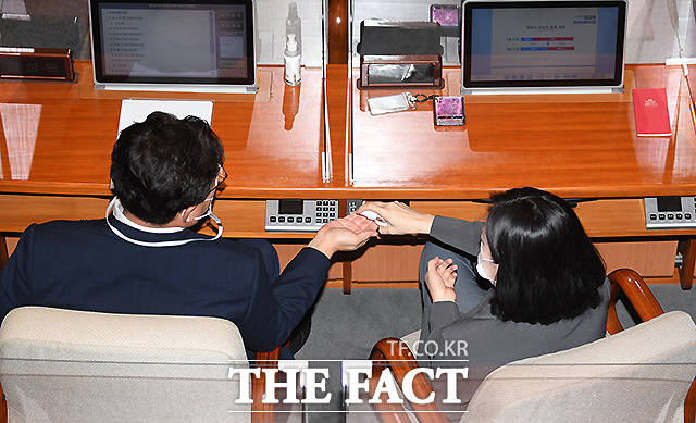 선배 먼저! 김성원 원내수석부대표(왼쪽)에게 손세정제 나눠 주는 배현진 원내대변인