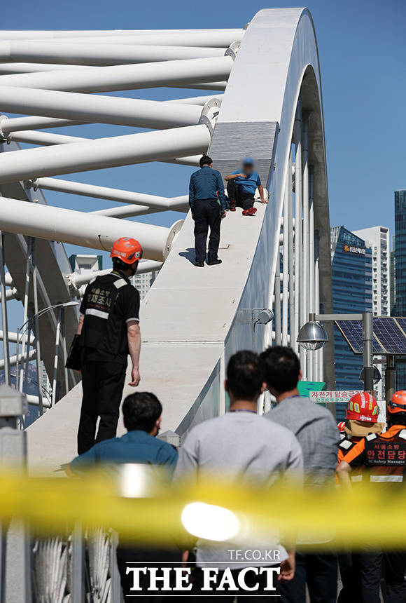 22일 오후 50대 남성이 서울 영등포에서 마포로 넘어가는 양화대교 시설물 위에 올라가 경찰 및 소방대원 등과 대치하고 있다./사진=뉴시스