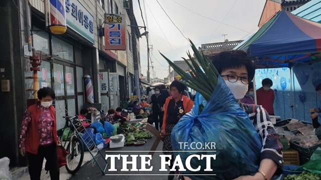 식자재 구입을 마친 한 시민이 야채를 한 아름 끌어안고 집으로 향하고 있다. /이경민 기자