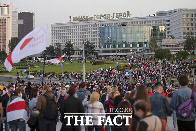 23일(현지시간) 벨라루스 수도 민스크에서 알렉산드르 루카셴코 대통령의 기습 취임에 항의하는 시위가 열린 가운데 시민들이 깃발을 들고 광장에 모여들고 있다. / 민스크=AP.뉴시스