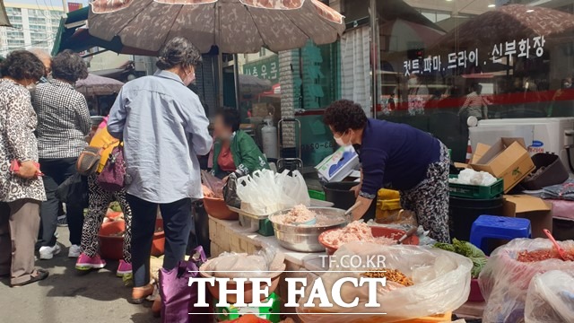 마스크를 착용하지 않은 한 시민과 상인이 흥정을 벌이고 있다. /이경민 기자