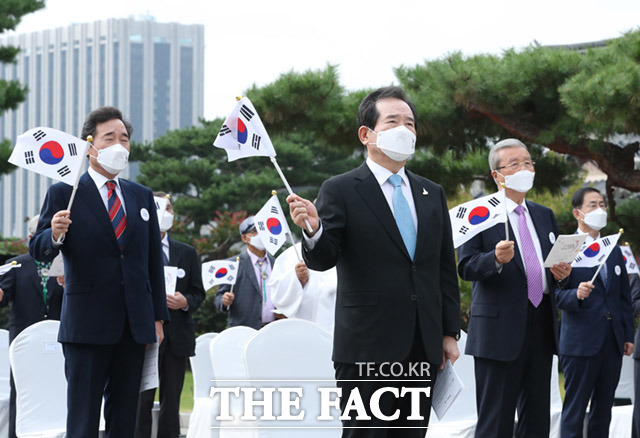 정세균 국무총리, 더불어민주당 이낙연 대표와 국민의힘 김종인 비상대책위원장이 3일 오전 서울 경복궁 내 국립민속박물관 앞 광장에서 열린 제4352주년 개천절 경축식에 참석해 태극기를 흔들고 있다./사진공동취재단