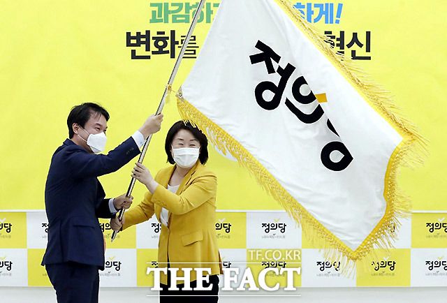 김종철 정의당 신임 대표(왼쪽)와 심상정 전 대표가 11일 오전 서울 여의도 국회에서 열린 5·6기 지도부 이·취임식에서 당 깃발을 흔들고 있다. /정의당 제공
