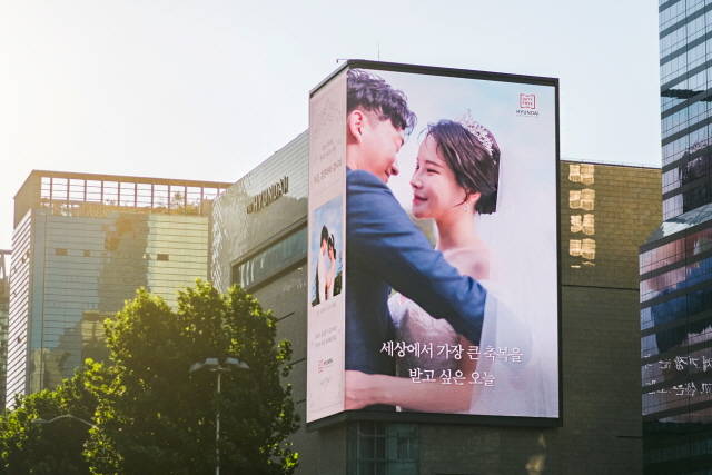 15일 현대백화점면세점 무역센터점 외벽에 설치된 초대형 디지털 사이니지에서 랜선 웨딩 이벤트를 진행하고 있다. /현대백화점면세점 제공