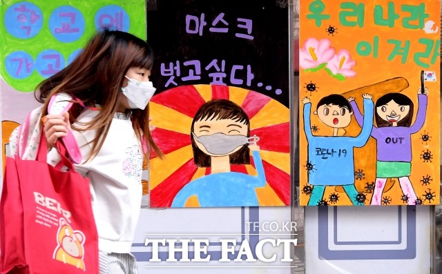 교육부가 오는 19일부터 대부분 시·도교육청이 학교생활 적응을 이유로 초등학교 1학년을 매일 등교시키기로 했다.서울 마포구 동교초등학교 인근 거리에서 어린이가 코로나 관련 그림을 바라보며 걸어가고 있다. /이선화 기자