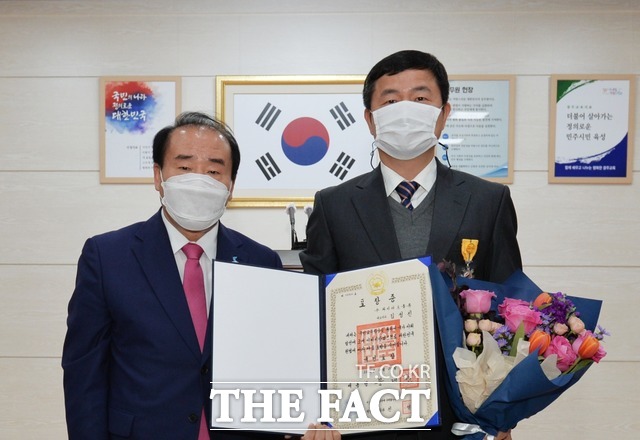 2일 장휘국 광주시교육감(왼쪽)은 2020년 국민교육발전 유공자로 선정된 (재)빛고을결식학생후원재단 김성진 이사장(㈜와이마트물류 대표 오른쪽)에 대해 국민포장을 전수하고 기념활영하고 있다./ 광주시교육청 제공