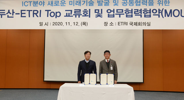 12일 한국전자통신연구원(ETRI) 대전본원에서 열린 ㈜두산과 ETRI의 ‘ICT  분야 미래기술 발굴 및 협력’ 협약식에서 동현수 ㈜두산 부회장(왼쪽)과 김명준 ETRI 원장이 협약서에 서명을 마치고 기념촬영을 하고 있다./두산 제공
