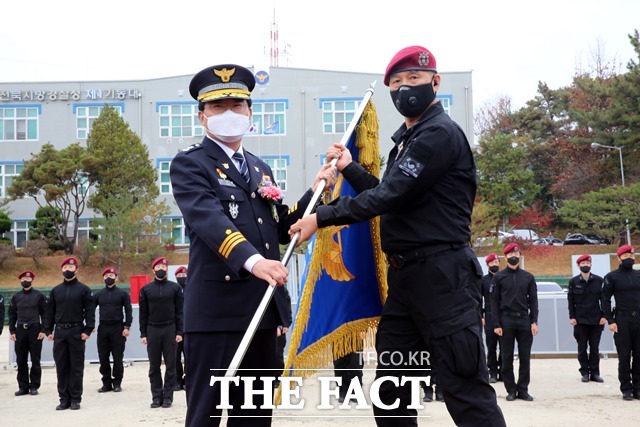 18일 오전 전북 완주군 전북경찰특공대 청사에서 열린 경찰특공대창설식에서 진교훈 전북지방경찰청장이 김용환 특공대장에게 깃발을 건네고 있다. /전북지방경찰청 제공