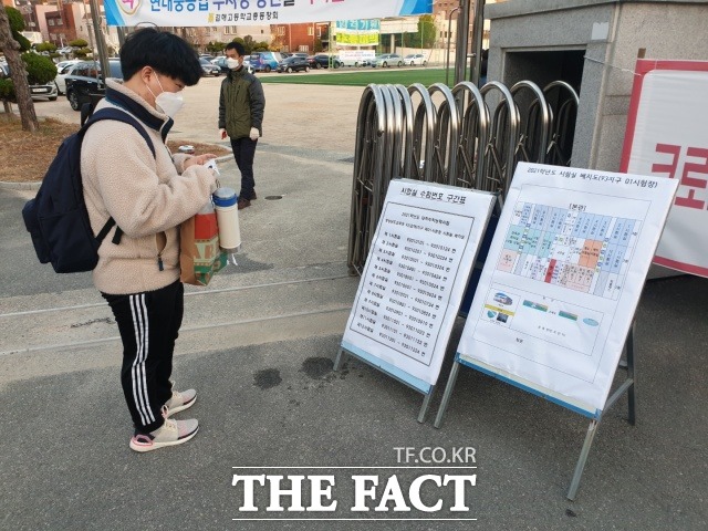 경남 김해시 한 고등학교에 시험을 치르기 위해 도착한 수험생이 수능 안내표를 꼼꼼히 살펴보고 있다. /경남=강보금 기자