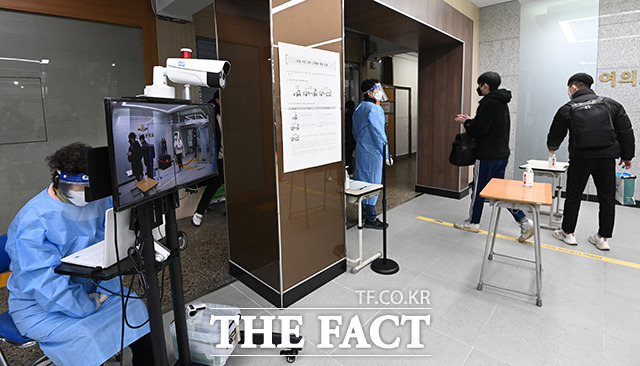 2021학년도 대학수학능력시험일인 3일 오전 서울 영등포구 여의동 여의도고에서 안내교사의 지시에 따라 수험생들이 발열체크를 하며 고사장으로 들어가고 있다. / 사진공동취재단