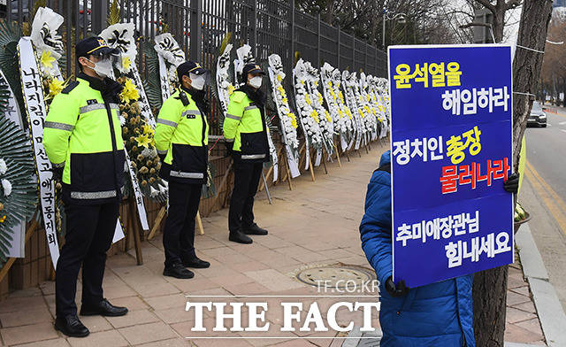 10일 오전 경기도 과천 정부과천청사에서 윤석열 검찰총장에 대한 징계 수위를 결정하는 징계위가 열린 가운데 청사 입구에 법무부를 비난하는 조화 앞에서 추미애 장관 지지자가 피켓 시위를 하고 있다./과천=임영무 기자